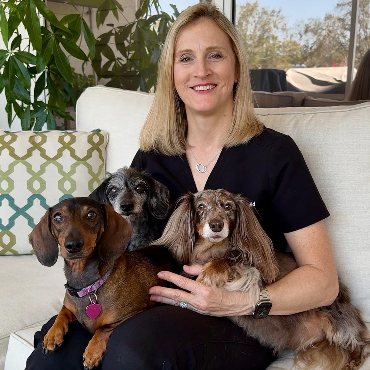 Dr Reagan McDonald DVM Sitting On The Couch With Her Three Dogs